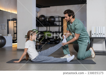 Specialist performing foot and ankle gymnastics with girl Specialist performing foot and ankle gymnastics with girl 138035173
