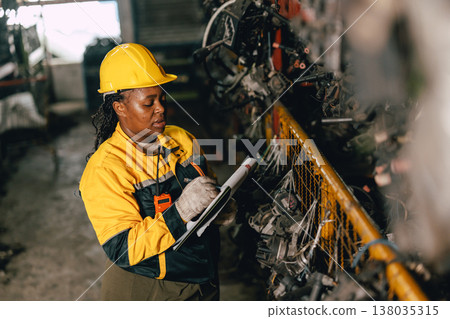 African black women engineer worker working in old used machine part stock warehouse. African black women engineer worker working in old used machine part stock warehouse. 138035315