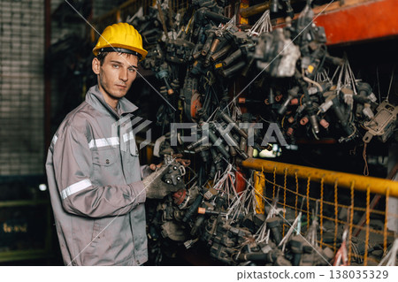 Engineer technician male worker work in old used machine part stock warehouse. 138035329