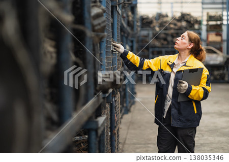 Technician adult women worker working in heavy industry, warehouse manager in garage scrap yard Technician adult women worker working in heavy industry, warehouse manager in garage scrap yard 138035346