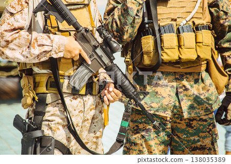 Modern soldiers dressed in camouflage. Military army with tactical weapon closeup 138035389