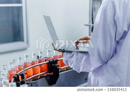 Closeup worker using laptop record products data at production line in food and drinks factory Closeup worker using laptop record products data at production line in food and drinks factory 138035411
