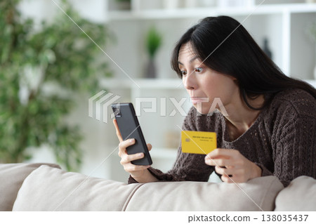 Perplexed asian woman buying online with phone Perplexed asian woman buying online with phone 138035437