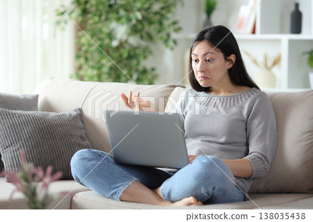 Perplexed asian woman checking online content on laptop Perplexed asian woman checking online content on laptop 138035438