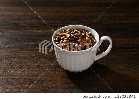 白色杯子裡的咖啡豆,背景是木紋。 白色杯子裡的咖啡豆,背景是木紋。 138035841