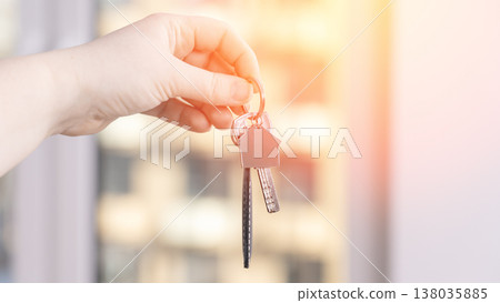 Hand holds keys with house-shaped keychain Hand holds keys with house-shaped keychain 138035885