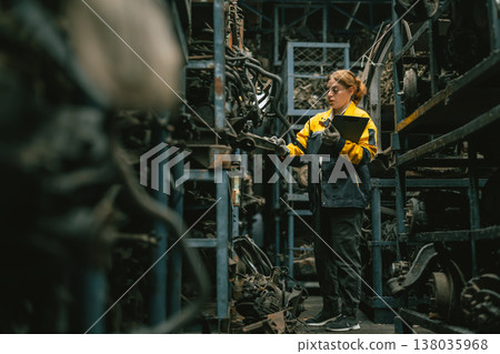 Technician adult women worker working in heavy industry, warehouse manager in garage scrap yard Technician adult women worker working in heavy industry, warehouse manager in garage scrap yard 138035968