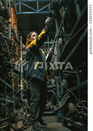 Technician adult women worker working in heavy industry, warehouse manager in garage scrap yard 138035971