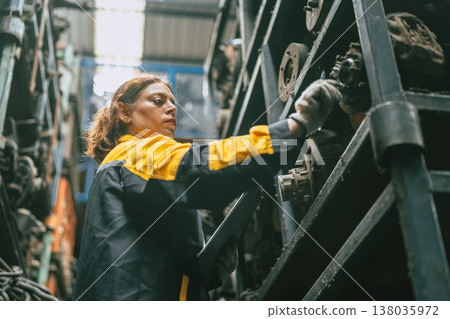 Technician adult women worker working in heavy industry, warehouse manager in garage scrap yard Technician adult women worker working in heavy industry, warehouse manager in garage scrap yard 138035972