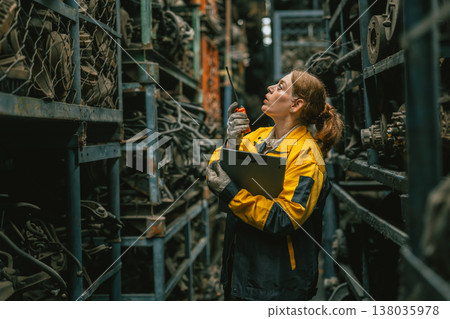Technician adult women worker working in heavy industry, warehouse manager in garage scrap yard 138035978