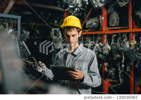 Technician male worker working in garage scrap yard old car part workshop warehouse 138036065