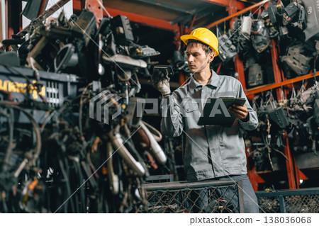 Technician male worker working in garage scrap yard old car part workshop warehouse 138036068