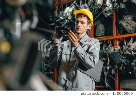 Technician male worker working in garage scrap yard old car part workshop warehouse Technician male worker working in garage scrap yard old car part workshop warehouse 138036069