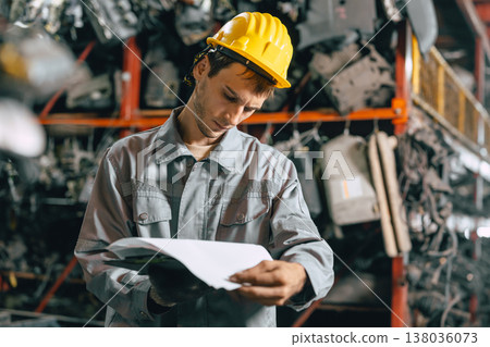 Technician male worker working in garage scrap yard old car part workshop warehouse 138036073