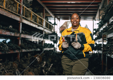 Happy Black African women engineer worker enjoy working in old used machine part stock warehouse. Happy Black African women engineer worker enjoy working in old used machine part stock warehouse. 138036080