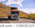 Japanese truck moving by a mountain road in autumn 138036129