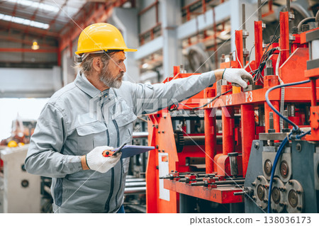 Professional senior Industrial worker in protective helmet and uniform service machinery in factory 138036173