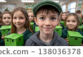 Smiling caucasian school children holding green paper houses in classroom celebrating creative school project 138036378