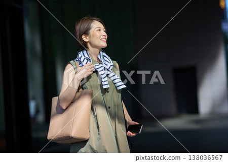 A Japanese woman smiling outdoors in the city. A Japanese woman smiling outdoors in the city. 138036567