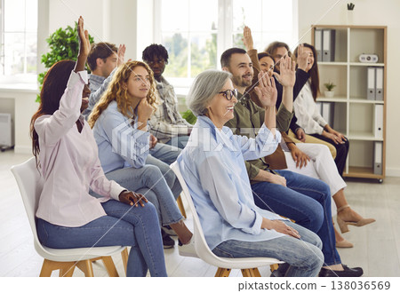 People colleagues raising hands to ask questions during business meeting in office. People colleagues raising hands to ask questions during business meeting in office. 138036569