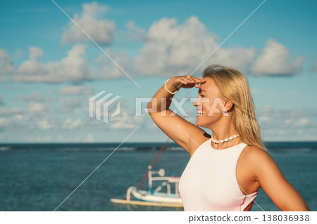 Woman stands by the water while looking at the horizon Woman stands by the water while looking at the horizon 138036938