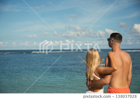 Couple looks at ocean waves from beach in Bali 138037028