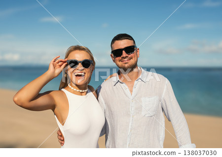 Couple smiles at the beach with clear sky and ocean view 138037030