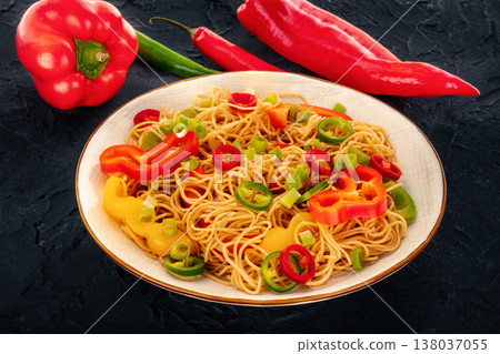 Hakka noodles with vegetables, shot with red peppers on black 138037055