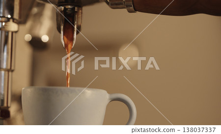 closeup shot of pouring espresso with coffee machine into ceramic cup closeup shot of pouring espresso with coffee machine into ceramic cup 138037337