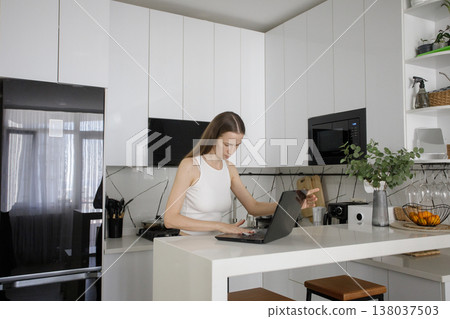 Attractive woman cleaning her laptop at home 138037503