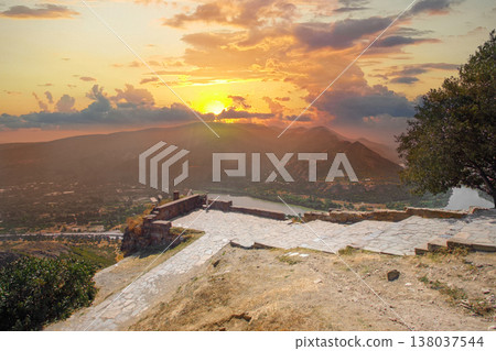 Orange sunset sky in Georgia. Georgian monastery in mountain Orange sunset sky in Georgia. Georgian monastery in mountain 138037544