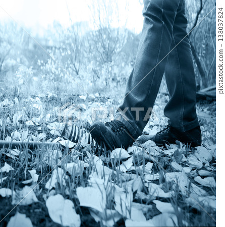 The foot steps on a lying rake 138037824