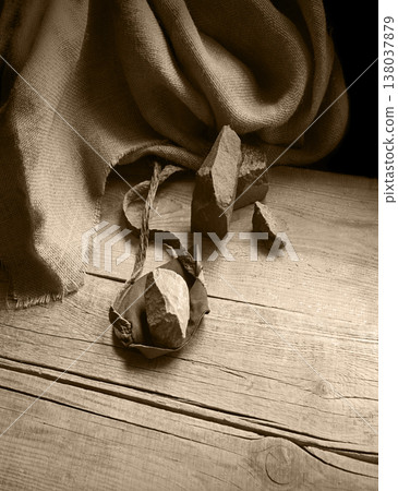 An antique leather sling lies on wooden desk 138037879