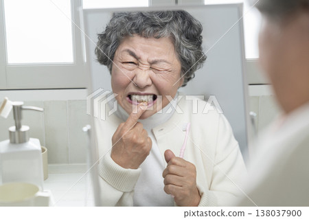 老年婦女在刷牙時開始擔心牙齦不適。 138037900