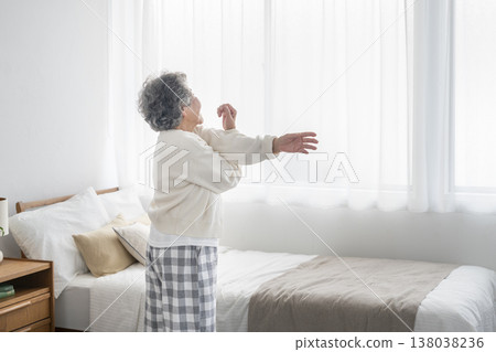 一位老婦人在床前伸懶腰(從後面拍攝) 一位老婦人在床前伸懶腰(從後面拍攝) 138038236