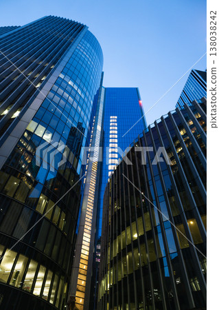Low angle view of modern glass skyscrapers at twilight Low angle view of modern glass skyscrapers at twilight 138038242