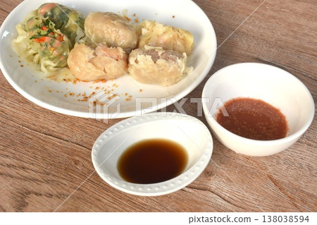 steamed Chinese dumpling stuffing shrimp and chop pork with vegetable on plate dipping soy sauce  138038594
