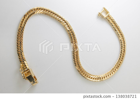An overhead photograph of a Cuban link bracelet arranged in an S-shape against a white background. An overhead photograph of a Cuban link bracelet arranged in an S-shape against a white background. 138038721