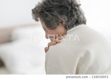 The back view of a senior woman holding her shoulder. The back view of a senior woman holding her shoulder. 138038953