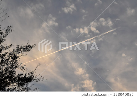Look up to the sky at sunset with contrails clouds in the sky. Beautiful cloudscape in the evening. Nature scene. Look up to the sky at sunset with contrails clouds in the sky. Beautiful cloudscape in the evening. Nature scene. 138040085