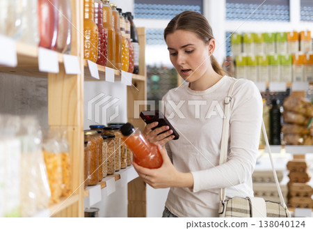 Young woman scanning qr code of grapefruit juice 138040124