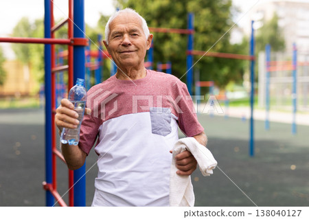 Old man in outdoor workout station 138040127