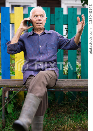 Senior man talking on phone outdoors 138040148