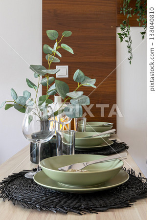 modern dining table setting with eucalyptus 138040810