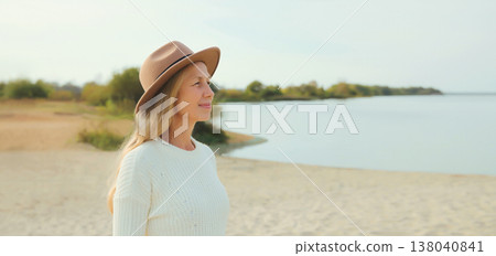 Happy woman on beach, wear hat standing on sea coast background Happy woman on beach, wear hat standing on sea coast background 138040841