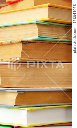 Books stacked on a table showing worn spines and pages in a reading area Books stacked on a table showing worn spines and pages in a reading area 138041058