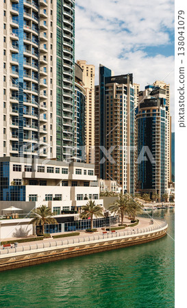 Modern buildings line the waterfront in a busy city area during daytime Modern buildings line the waterfront in a busy city area during daytime 138041079