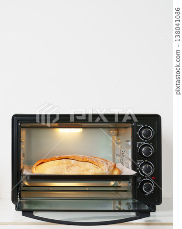 Toaster oven with bread cooking inside on kitchen counter Toaster oven with bread cooking inside on kitchen counter 138041086