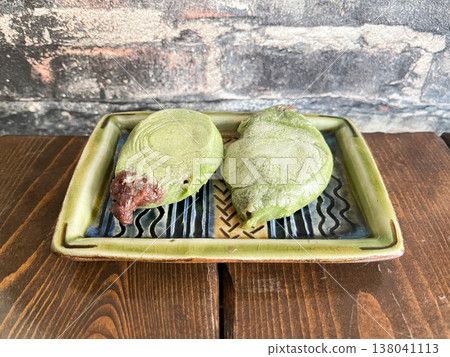 Yomogi mochi is a type of baked Japanese confection. It is a Japanese sweet in which red bean paste is wrapped in mochi (rice cake) kneaded with mugwort. Yomogi mochi is a type of baked Japanese confection. It is a Japanese sweet in which red bean paste is wrapped in mochi (rice cake) kneaded with mugwort. 138041113