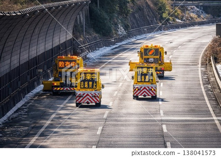 A convoy of snowplows traveling on a highway in winter / Road maintenance work in progress V2 A convoy of snowplows traveling on a highway in winter / Road maintenance work in progress V2 138041573